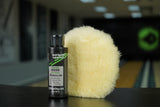 A photo of a Premium Polish Pad with a bottle of TruCut Hand Applied Polish Powered by Turtle Wax in a bowling alley