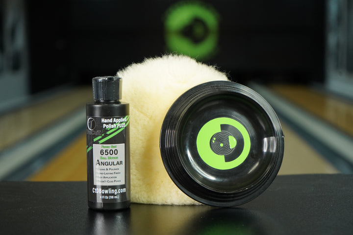 4oz TruCut Hand Applied Polish Plus, a CtD Premium Polishing Pad, and a CtD Ball Cup on a table in a bowling alley