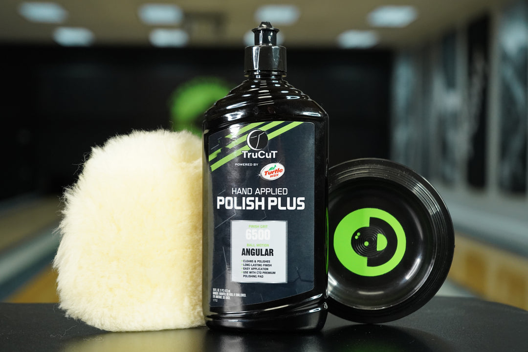 16oz TruCut Hand Applied Polish Plus, a CtD Premium Polishing Pad, and a CtD Ball Cup on a table in a bowling alley
