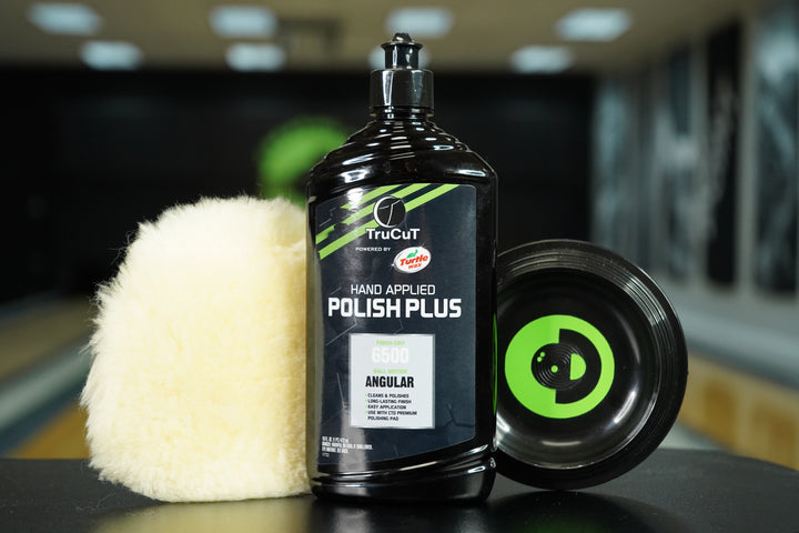 16oz TruCut Hand Applied Polish Plus, a CtD Premium Polishing Pad, and a CtD Ball Cup on a table in a bowling alley